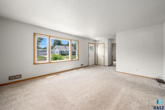 1422 E 17th St, Sioux Falls, SD 57104 - empty room with light carpet, baseboards, and a textured ceiling