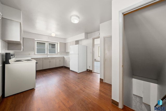 1422 E 17th St, Sioux Falls, SD 57104 - kitchen with white appliances, dark wood-type flooring, light countertops, baseboards, and a sink