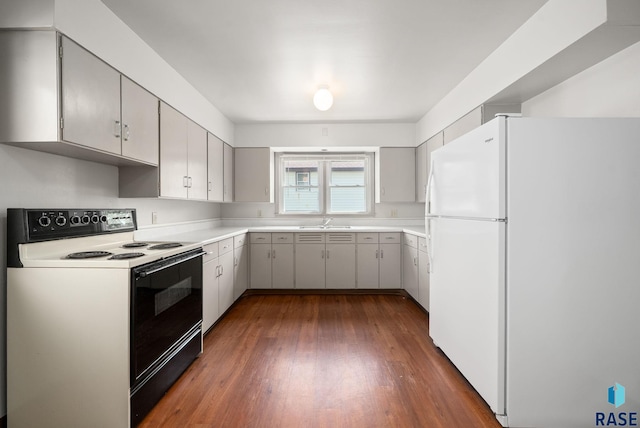 1422 E 17th St, Sioux Falls, SD 57104 - kitchen with electric range oven, freestanding refrigerator, a sink, dark wood-type flooring, and light countertops