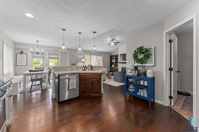 1913 S Haraldson Ave, Sioux Falls, SD 57106 - kitchen with stainless steel appliances, a chandelier, light countertops, dark wood-type flooring, and a textured ceiling