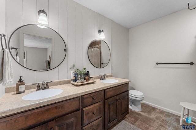 1913 S Haraldson Ave, Sioux Falls, SD 57106 - full bath with double vanity, toilet, baseboards, and stone finish floors