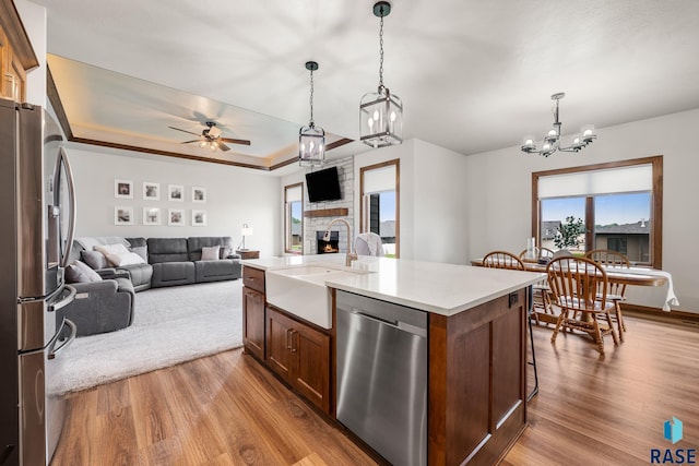 5604 E Daybreak Cir, Sioux Falls, SD 57110 - kitchen featuring stainless steel appliances, a sink, a chandelier, open floor plan, and wood finished floors