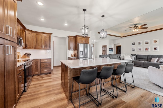 5604 E Daybreak Cir, Sioux Falls, SD 57110 - kitchen with appliances with stainless steel finishes, open floor plan, light wood finished floors, a kitchen breakfast bar, and recessed lighting