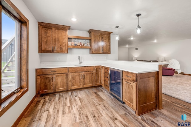 5604 E Daybreak Cir, Sioux Falls, SD 57110 - kitchen featuring beverage cooler, open floor plan, a peninsula, open shelves, and light wood-style flooring