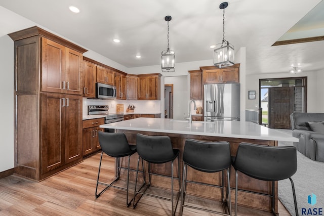 5604 E Daybreak Cir, Sioux Falls, SD 57110 - kitchen with appliances with stainless steel finishes, a sink, light wood-style floors, recessed lighting, and a breakfast bar area