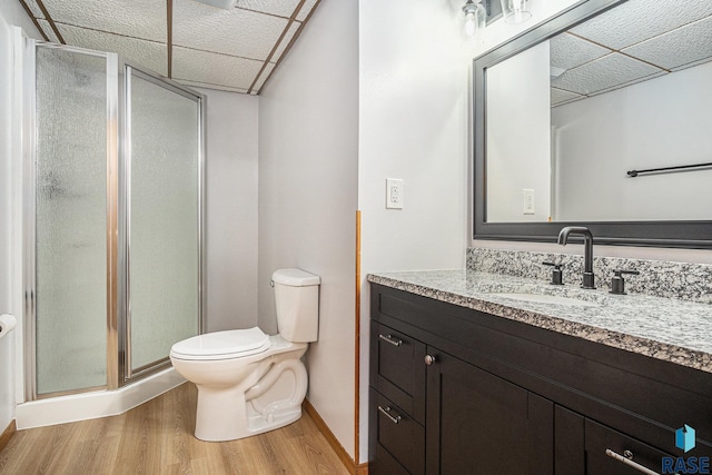 905 S Suburban Dr, Sioux Falls, SD 57110 - bathroom with wood finished floors, toilet, a shower stall, vanity, and baseboards