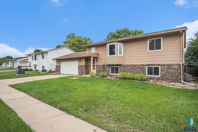 905 S Suburban Dr, Sioux Falls, SD 57110 - view of front of house with brick siding, a garage, a front lawn, and concrete driveway