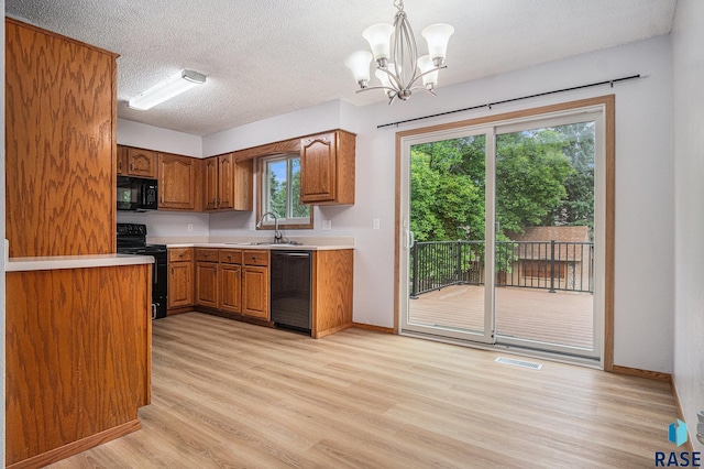 905 S Suburban Dr, Sioux Falls, SD 57110 - kitchen with black appliances, a sink, brown cabinets, light wood finished floors, and a chandelier