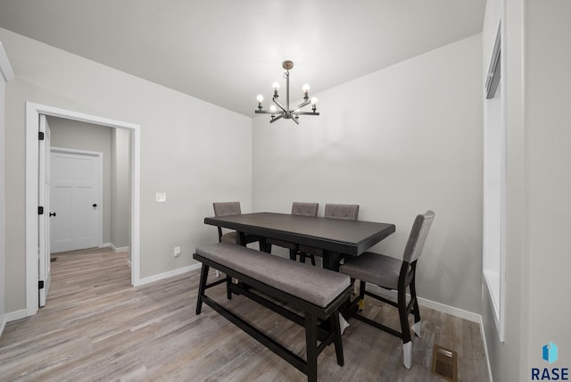 9001 W Rathburn St, Sioux Falls, SD 57103 - dining area with a chandelier, baseboards, and light wood-style flooring