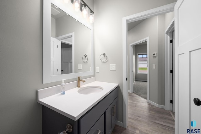 9001 W Rathburn St, Sioux Falls, SD 57103 - bathroom featuring vanity, wood finished floors, and baseboards