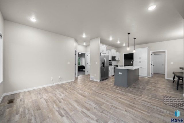 9001 W Rathburn St, Sioux Falls, SD 57103 - kitchen with stainless steel appliances, a kitchen island with sink, recessed lighting, open floor plan, and light countertops
