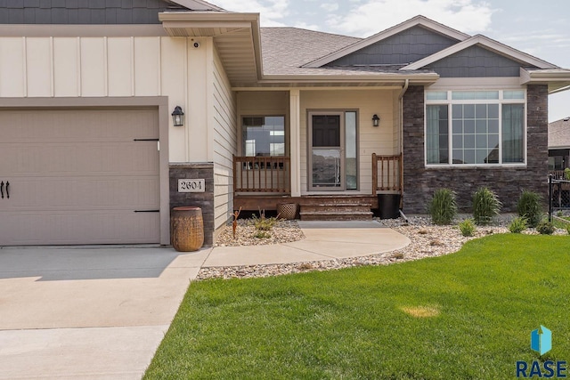 2604 S Ronell Cir, Sioux Falls, SD 57106 - entrance to property featuring stone siding, a lawn, a garage, board and batten siding, and concrete driveway