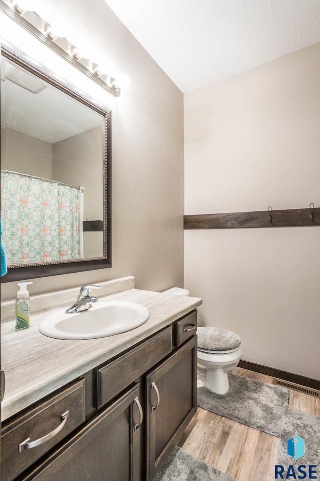 2604 S Ronell Cir, Sioux Falls, SD 57106 - full bathroom with vanity, wood finished floors, and toilet