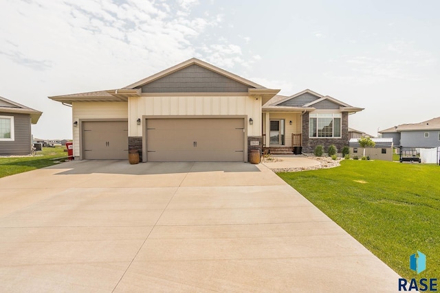 2604 S Ronell Cir, Sioux Falls, SD 57106 - craftsman house with stone siding, a front lawn, an attached garage, driveway, and board and batten siding