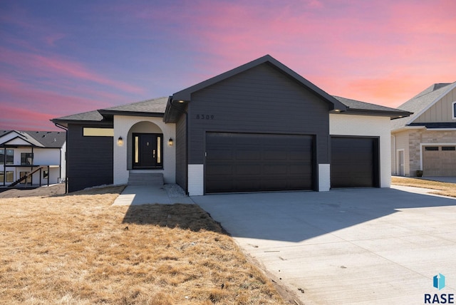 8309 E Sheridan Cir, Sioux Falls, SD 57110 - view of front of home with an attached garage, concrete driveway, and brick siding