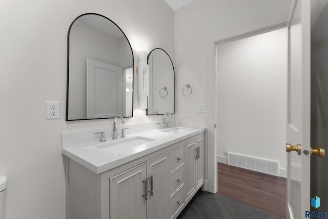 8309 E Sheridan Cir, Sioux Falls, SD 57110 - bathroom with double vanity, toilet, and wood finished floors