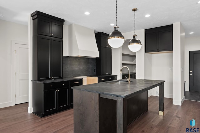 8309 E Sheridan Cir, Sioux Falls, SD 57110 - kitchen with premium range hood, a sink, dark countertops, dark wood-style flooring, and recessed lighting