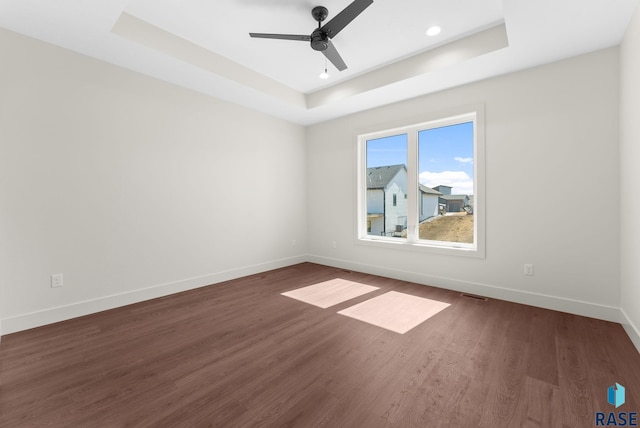 8309 E Sheridan Cir, Sioux Falls, SD 57110 - empty room featuring a raised ceiling, baseboards, dark wood-type flooring, ceiling fan, and recessed lighting