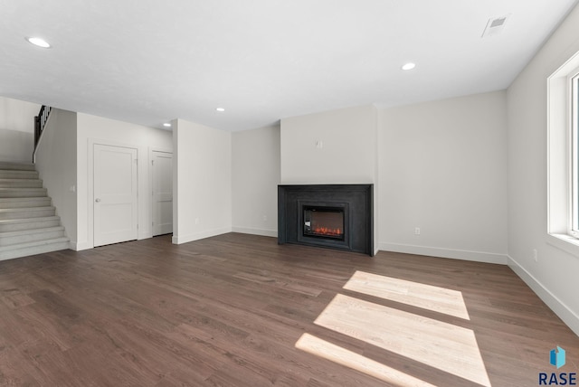 8309 E Sheridan Cir, Sioux Falls, SD 57110 - unfurnished living room featuring a glass covered fireplace, wood finished floors, stairway, baseboards, and recessed lighting