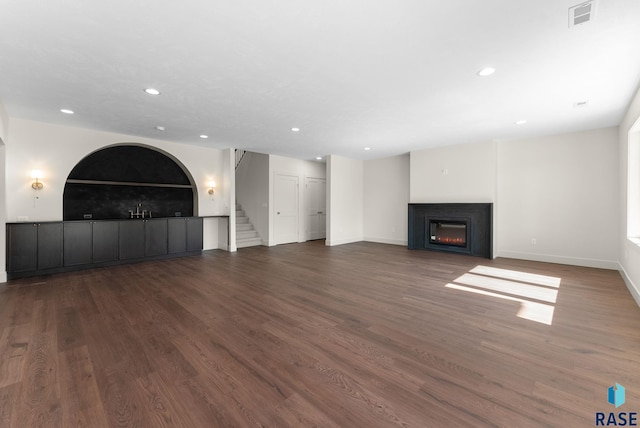 8309 E Sheridan Cir, Sioux Falls, SD 57110 - unfurnished living room with a warm lit fireplace, recessed lighting, baseboards, wood finished floors, and stairway