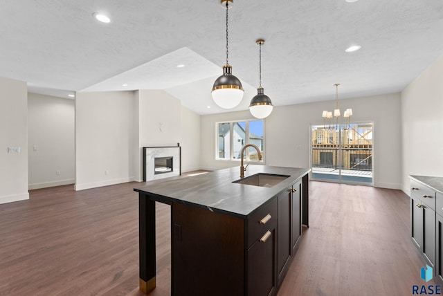 8309 E Sheridan Cir, Sioux Falls, SD 57110 - kitchen with a sink, dark wood finished floors, a high end fireplace, baseboards, and a chandelier