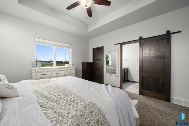 935 N Spencer Ln, Tea, SD 57064 - bedroom featuring a barn door, ensuite bathroom, ceiling fan, and baseboards