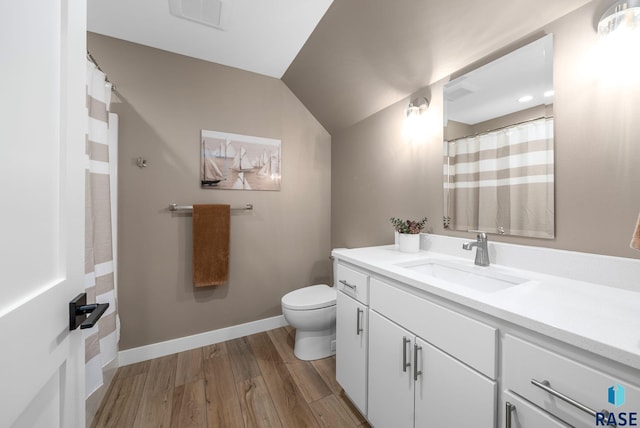 1703 N Otto Ave, Sioux Falls, SD 57110 - full bathroom with vanity, toilet, wood finished floors, vaulted ceiling, and baseboards