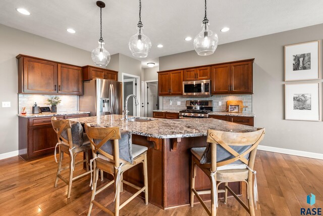 8216 W 51st St, Sioux Falls, SD 57106 - kitchen featuring stainless steel appliances, a sink, backsplash, baseboards, and recessed lighting