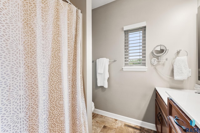 8216 W 51st St, Sioux Falls, SD 57106 - full bathroom featuring vanity, baseboards, toilet, curtained shower, and stone finish floors