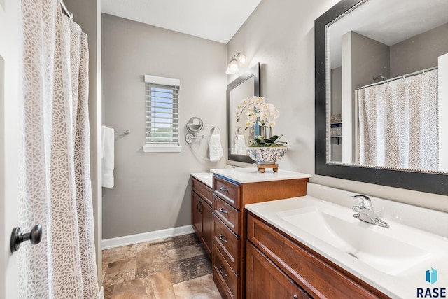 8216 W 51st St, Sioux Falls, SD 57106 - bathroom featuring vanity, baseboards, and stone finish flooring