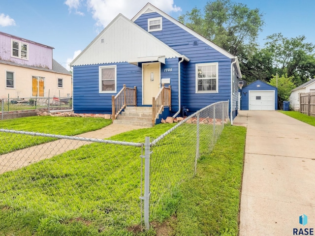 1705 W 10th St, Sioux Falls, SD 57104 - bungalow with concrete driveway, a detached garage, an outbuilding, and board and batten siding