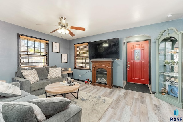 1705 W 10th St, Sioux Falls, SD 57104 - living room with wood finished floors, ceiling fan, a glass covered fireplace, arched walkways, and baseboards