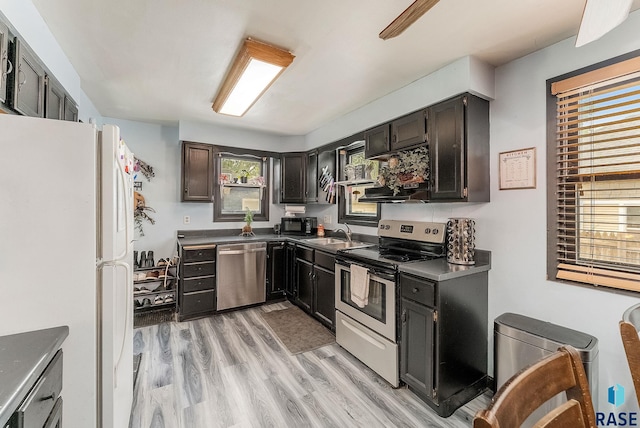 1705 W 10th St, Sioux Falls, SD 57104 - kitchen with stainless steel appliances, a sink, light wood-type flooring, and dark countertops