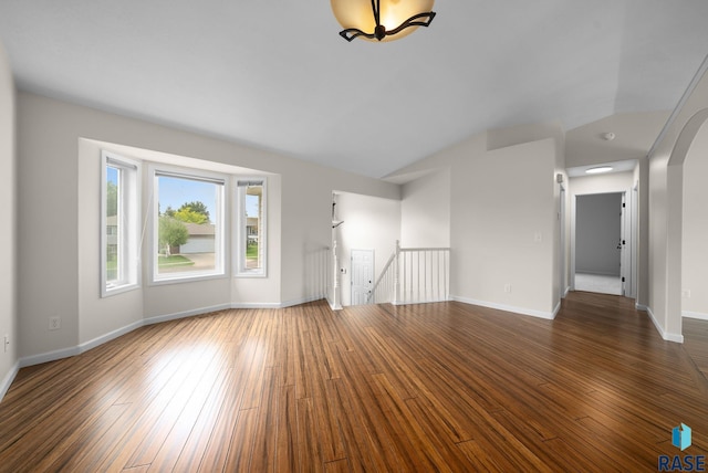 5600 W Darcie St, Sioux Falls, SD 57106 - unfurnished living room featuring hardwood / wood-style floors, arched walkways, baseboards, and vaulted ceiling