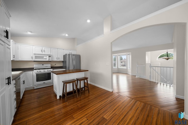 5600 W Darcie St, Sioux Falls, SD 57106 - kitchen with white appliances, arched walkways, lofted ceiling, white cabinets, and a kitchen island