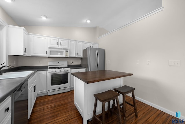5600 W Darcie St, Sioux Falls, SD 57106 - kitchen featuring white appliances, a sink, vaulted ceiling, a breakfast bar, and dark wood finished floors