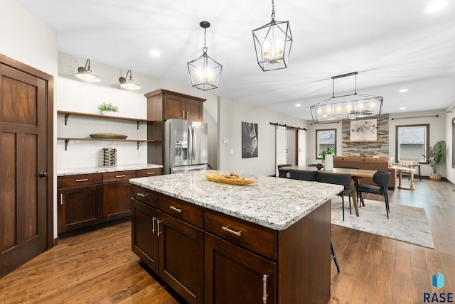 2101 S Meadowview Ave, Sioux Falls, SD 57110 - kitchen featuring stainless steel fridge, a barn door, open shelves, dark wood-style floors, and pendant lighting