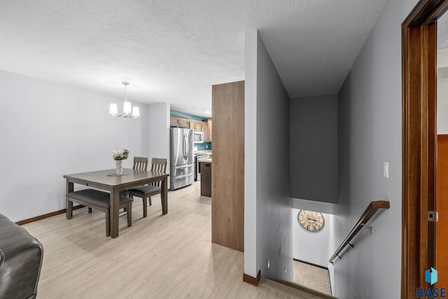 8620 W 22nd St, Sioux Falls, SD 57106 - hall featuring a chandelier, light wood finished floors, and an upstairs landing