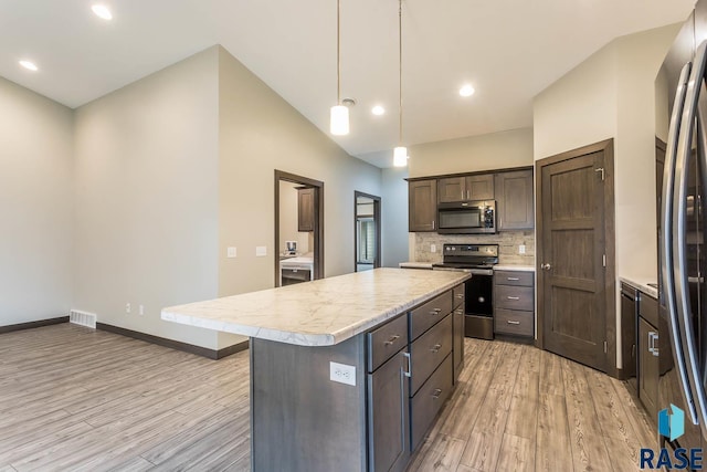 252 Devitt Dr, Harrisburg, SD 57032 - kitchen with appliances with stainless steel finishes, light wood-style floors, light countertops, dark brown cabinets, and a kitchen island