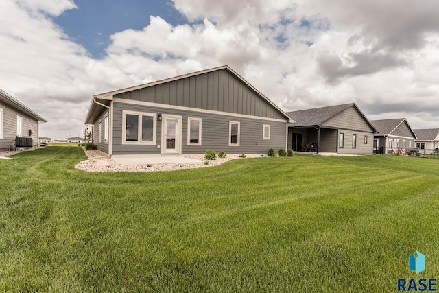 252 Devitt Dr, Harrisburg, SD 57032 - back of house with board and batten siding, a lawn, and a patio area
