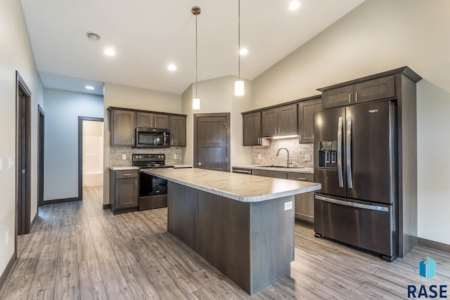 252 Devitt Dr, Harrisburg, SD 57032 - kitchen featuring stainless steel appliances, light countertops, dark brown cabinets, decorative backsplash, and light wood-style flooring