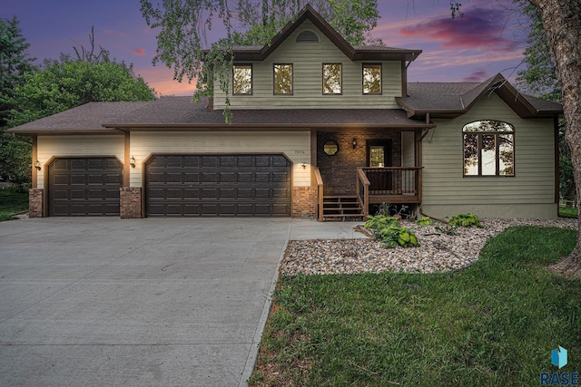 7604 E Palomino Rd, Sioux Falls, SD 57110 - view of front of house with concrete driveway, covered porch, brick siding, and an attached garage