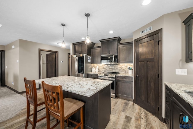 217 E Antioch St, Tea, SD 57064 - kitchen with stainless steel appliances, a kitchen breakfast bar, light wood-style floors, tasteful backsplash, and a kitchen island
