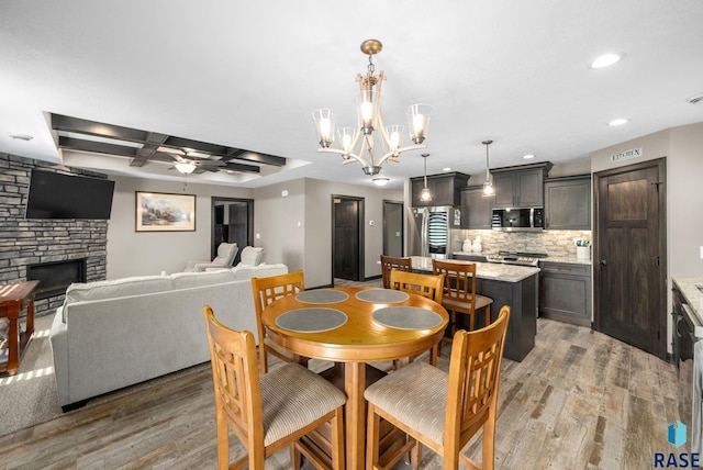 217 E Antioch St, Tea, SD 57064 - dining space with light wood-style floors, a fireplace, a ceiling fan, recessed lighting, and coffered ceiling