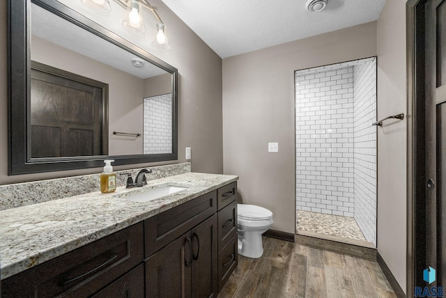 217 E Antioch St, Tea, SD 57064 - bathroom with vanity, a tile shower, wood finished floors, and a textured ceiling