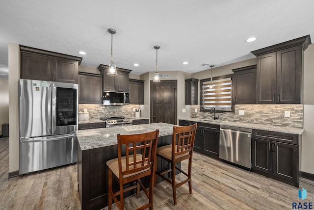 217 E Antioch St, Tea, SD 57064 - kitchen featuring stainless steel appliances, light wood-style flooring, dark brown cabinets, light stone countertops, and backsplash