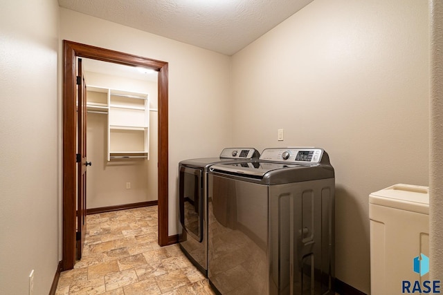 5509 E Eastbridge Pl, Sioux Falls, SD 57110 - laundry area with washer and clothes dryer, light stone finish floors, and a textured ceiling