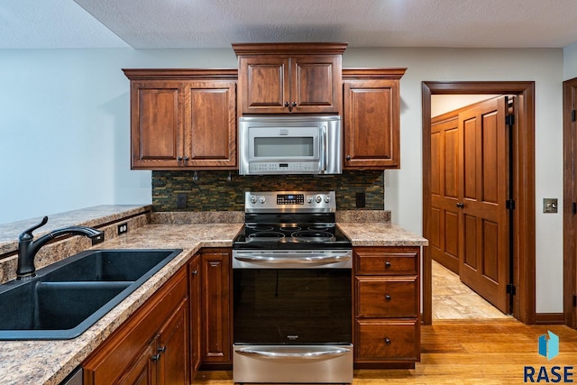 5509 E Eastbridge Pl, Sioux Falls, SD 57110 - kitchen featuring stainless steel electric range, light wood-style flooring, and tasteful backsplash