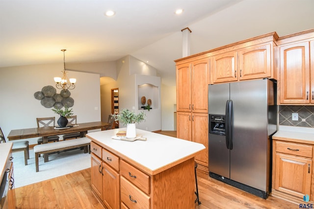 6312 S Heatherridge Ave, Sioux Falls, SD 57108 - kitchen with stainless steel fridge with ice dispenser, lofted ceiling, a kitchen island, light wood-style flooring, and backsplash