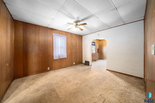 1407 N Main Ave, Sioux Falls, SD 57104 - spare room with arched walkways, light colored carpet, a ceiling fan, and wood walls